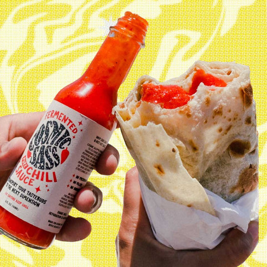 The vivid red chili sauce looks especially delectable on a burrito. The Cosmic Sass hot sauce is made to enhance flavors rather than to mask flavors. 